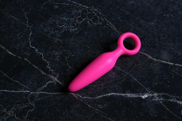 写真 黒い大理石の背景にピンクのお尻plug.sexおもちゃ。
