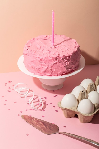 Foto torta rosa e composizione di candele ad alto angolo