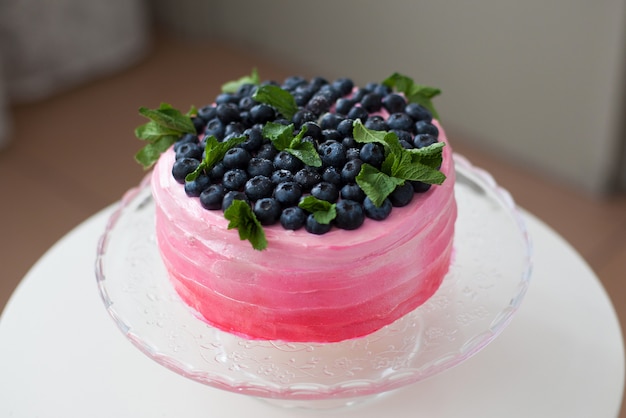 Pink cake decorated with blueberry and mint