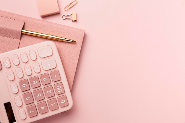 Фото Розовый калькулятор и аксессуары на розовом столе минимальная бизнес-концепция в стиле рабочего пространства