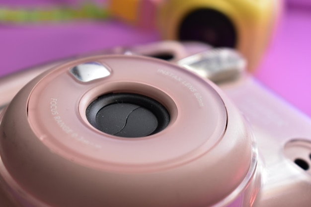 Розовый объектив камеры со словом nikon внизу.