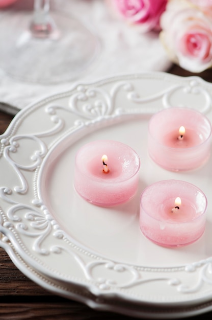 Photo pink candle and roses on the table