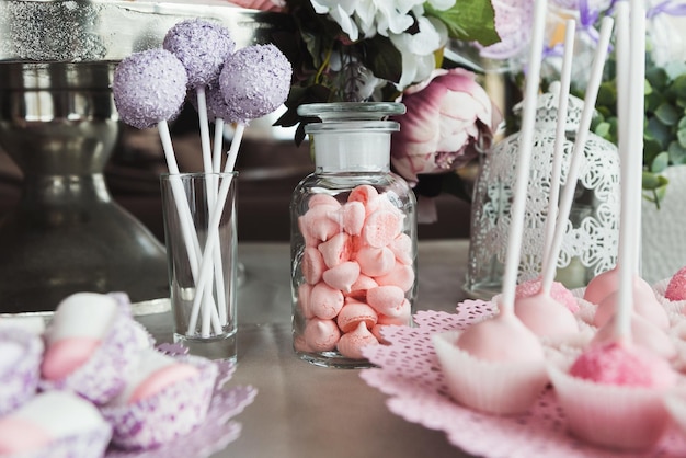 休日のお祝いのためのピンクのキャンディーバー。誕生日パーティーや結婚式のための甘いビュッフェ。木製の背景、ケータリングの概念に対するデザートの品揃え