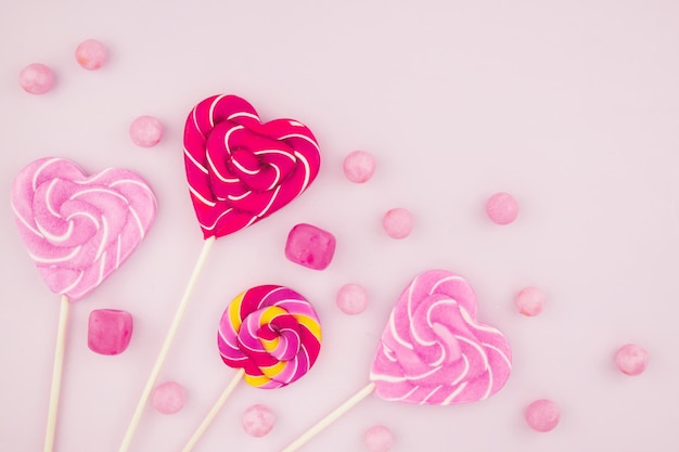 Pink candy lollipops and marshmallows are scattered sweet products of the confectionery factory