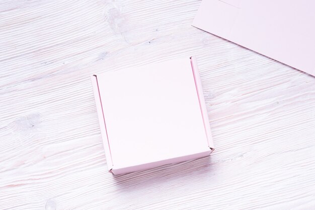 Pink Cardboard Carton box on white wood background