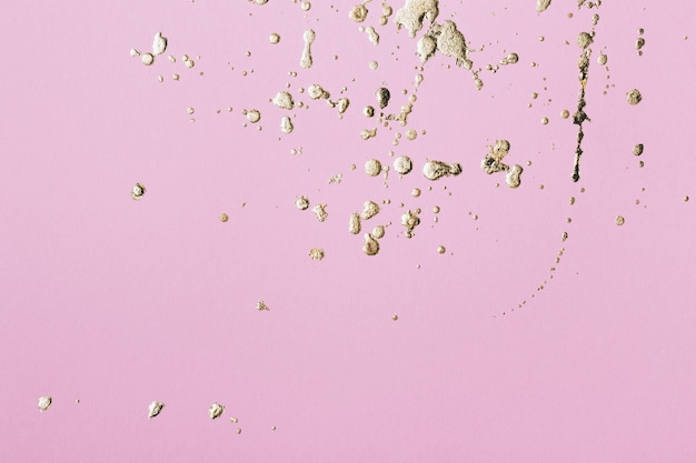 Pink cardboard with gold potal drops and splashes. Creative background, copy space.