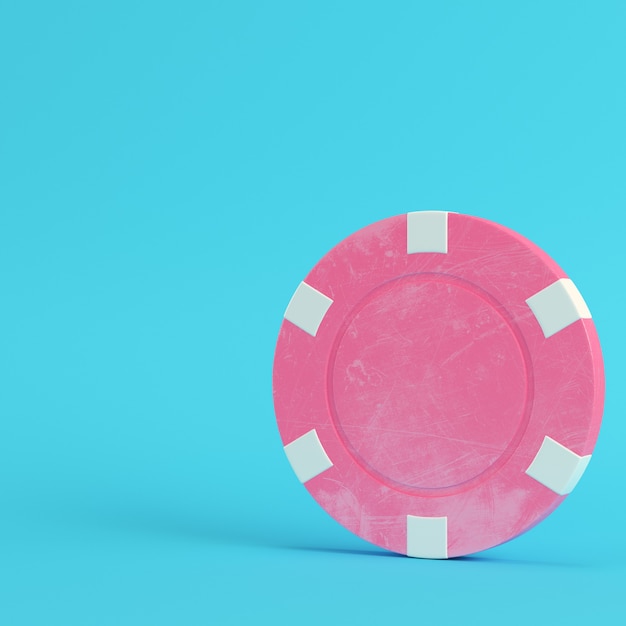 Pink casino chip on bright blue background