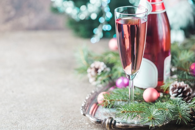 Pink champagne in a glass and christmas decorations