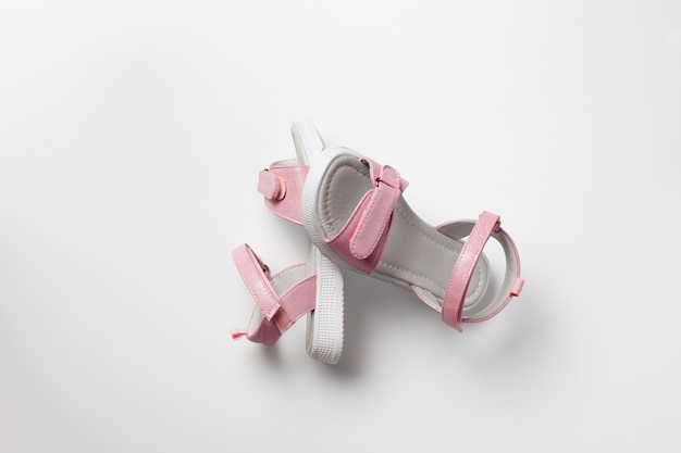 Sandali rosa per bambini in pelle lucida con chiusure in velcro suole piatte bianche isolate su...