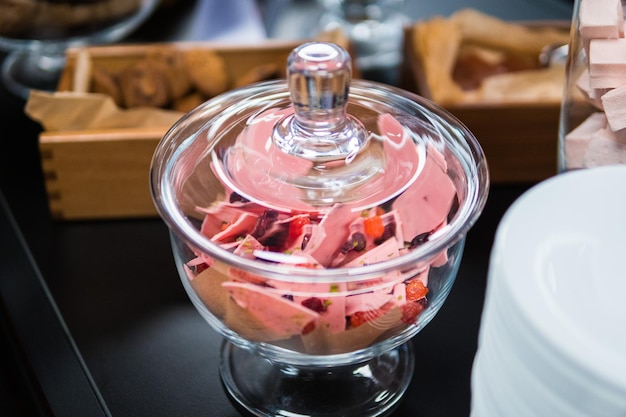 Pink chocolate in glassware and other sweets on the buffet table during the coffee break