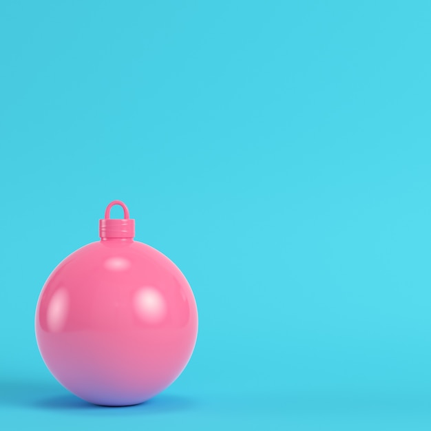 Pink christmas ball on bright blue background