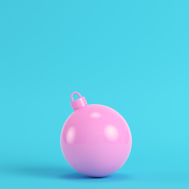 Pink christmas ball on bright blue background