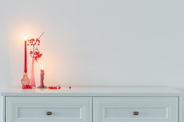 розовый рождественский декор с горящими свечами в белом интерьере