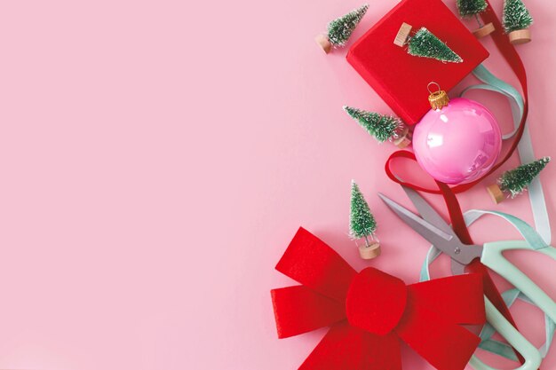 핑크 크리스마스 모던 크리스마스 플랫에는 빨간 활 싸구려 작은 나무와 분홍색 리본이 있습니다.