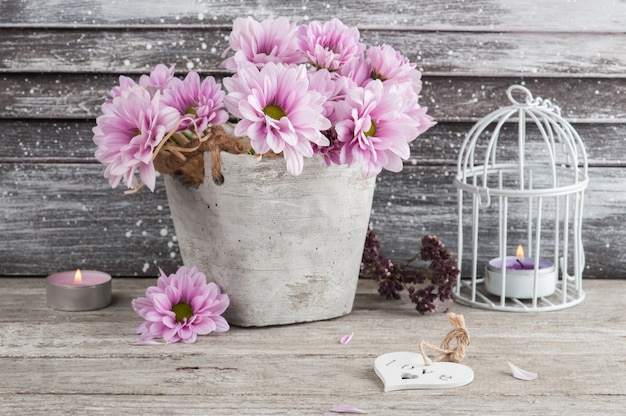 Pink chrysanthemum in concrete pot with candles