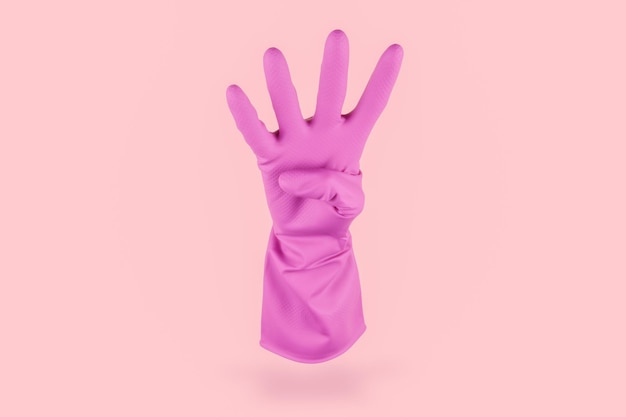 Pink cleaning glove counting four with his fingers on a pink background