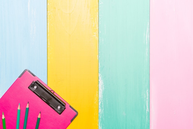 Pink clipboard top view on colorful backgrounds