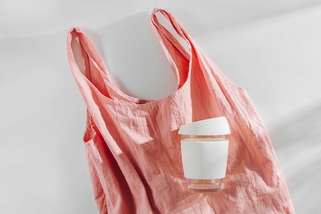 Pink cloth shopping bag and  reusable coffee mug. Zero waste, plastic free concept.