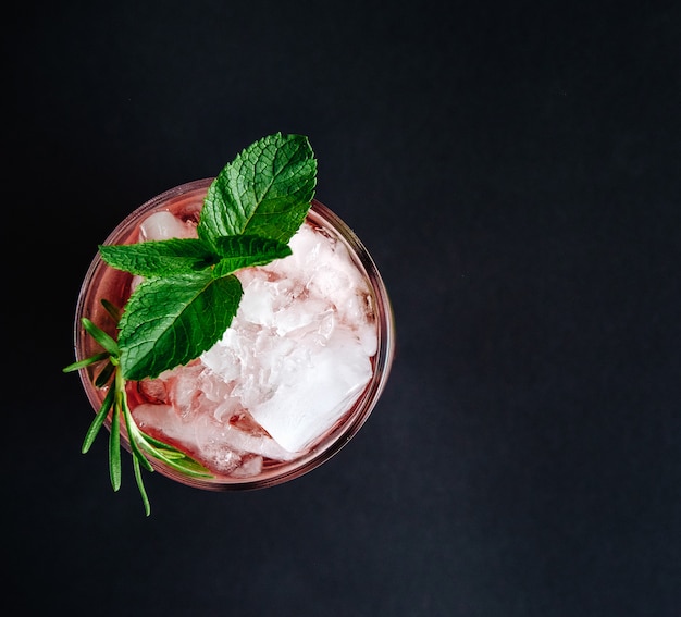 Cocktail rosa con la vista superiore del primo piano del rosmarino e della menta