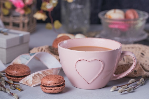 Pink coffee mug with sweet pastel french macaroons