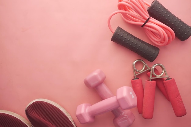 pink color dumbbell exercise mat and water bottle on white background