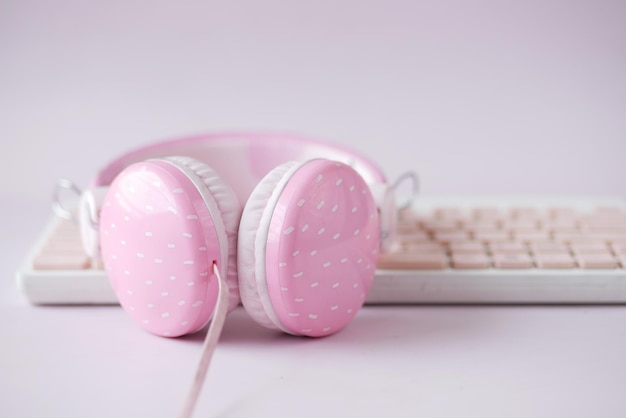 Pink color headphone on keyboard on pink