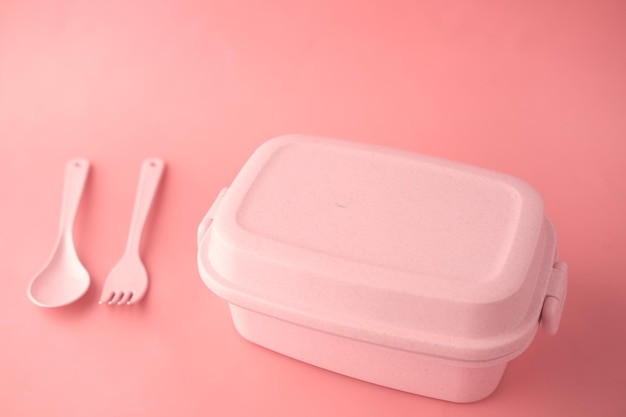 pink color lunch box on color background