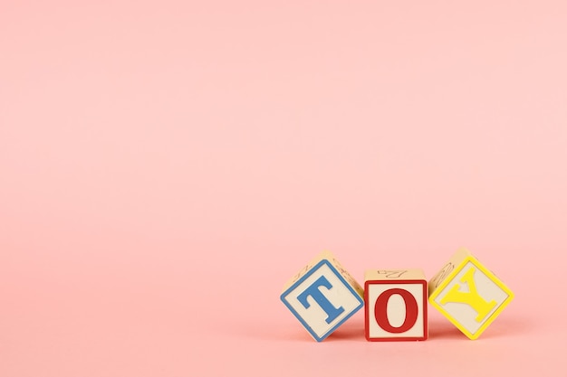 Pink  and colored cubes with letters with the inscription Toy