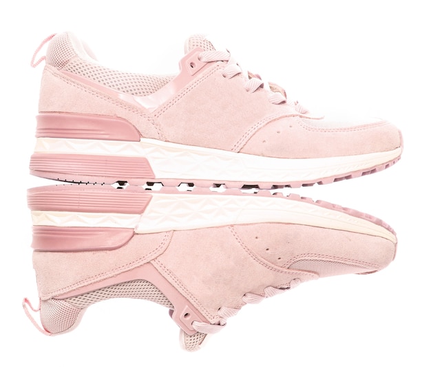 Pink colored sports sneakers isolated