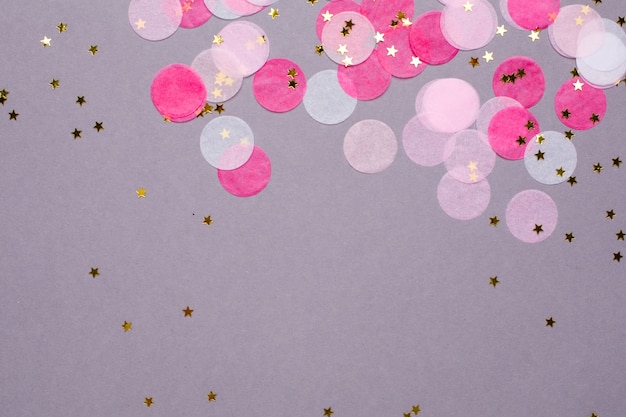 Pink confetti with gold stars on gray   with copyspace