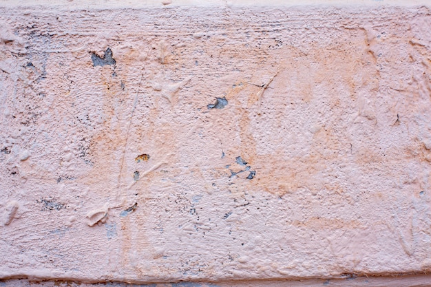 Pink, cracked paint on old wall crumbling houses