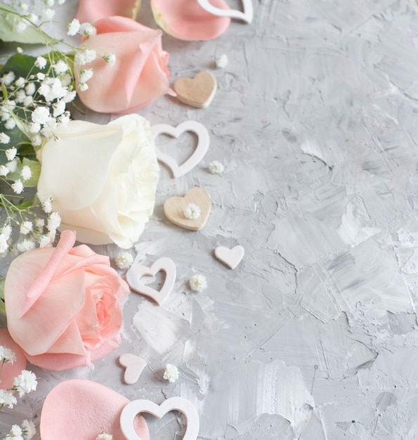 Pink and cream roses with hearts on a grey background