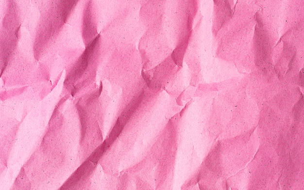 Pink crumpled recycle paper background close up with copy space