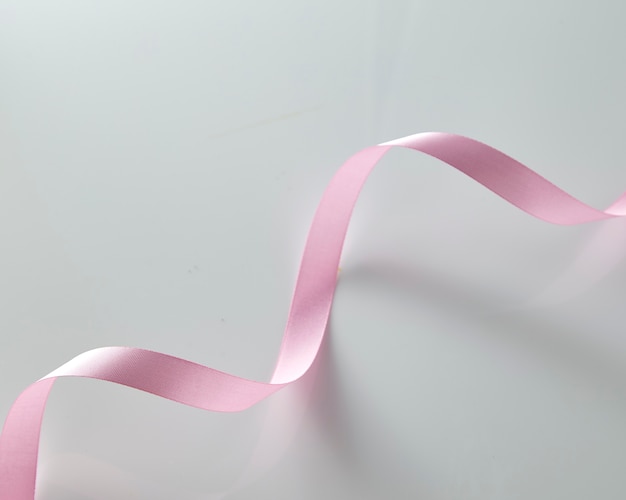 Pink curly ribbon on white