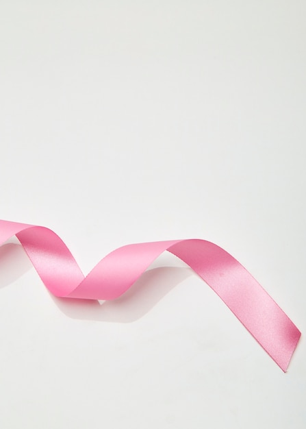 Pink curly ribbon on white