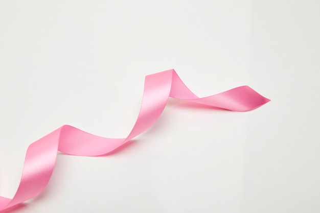 Pink curly ribbon on white