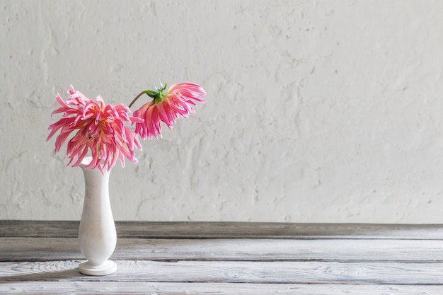 Pink dahlia in vase on wooden table