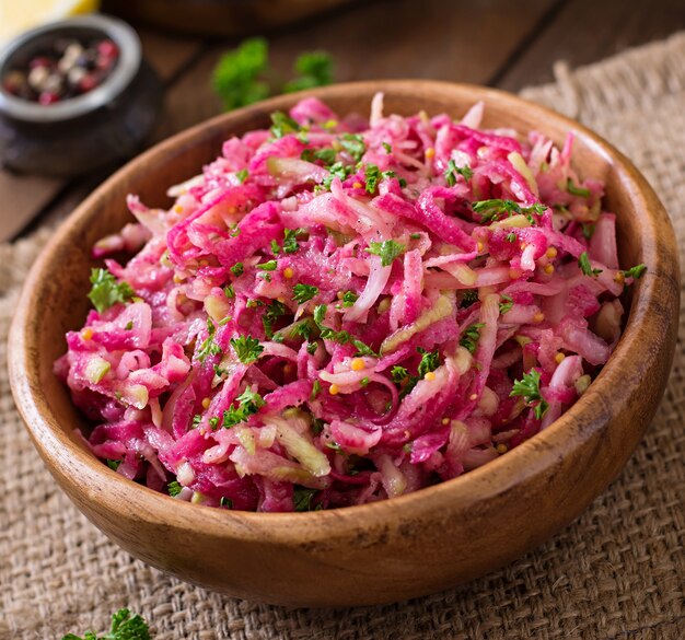 Foto insalata daikon rosa con mele, cipolle sottaceto e prezzemolo