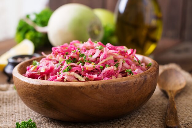 Foto insalata rosa di daikon con mele, cipolle sottaceto e prezzemolo