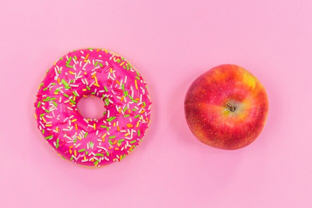 Pink donut and apple, healthy eating