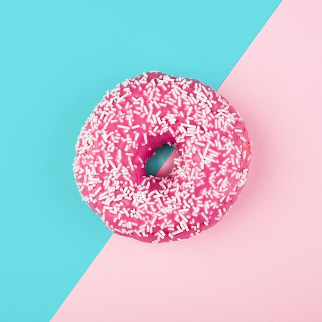 Pink donut on color background flat lay top view