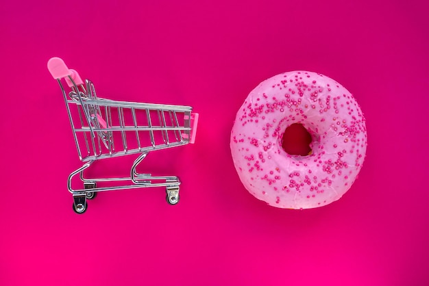 A pink donut with pink icing and a pink donut on a pink background.