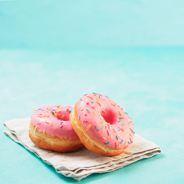 pink donuts on blue background copy space