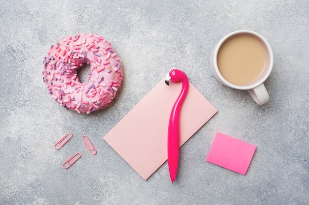 Pink doughnut and Cup of coffee Flamingo pen. Top view Flat lay.