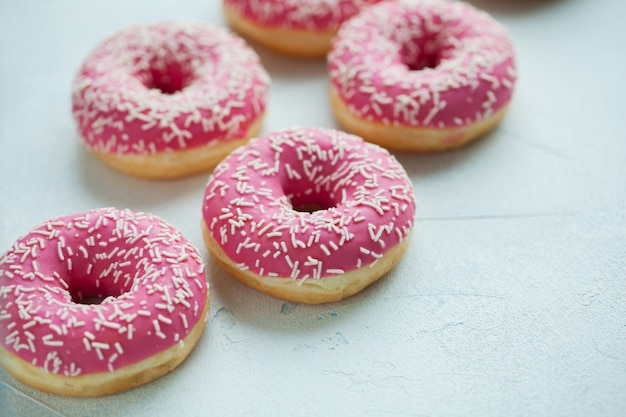 Pink doughnuts in icing sugar.