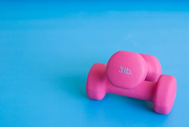 Фото Розовая гантель на коврике для йоги