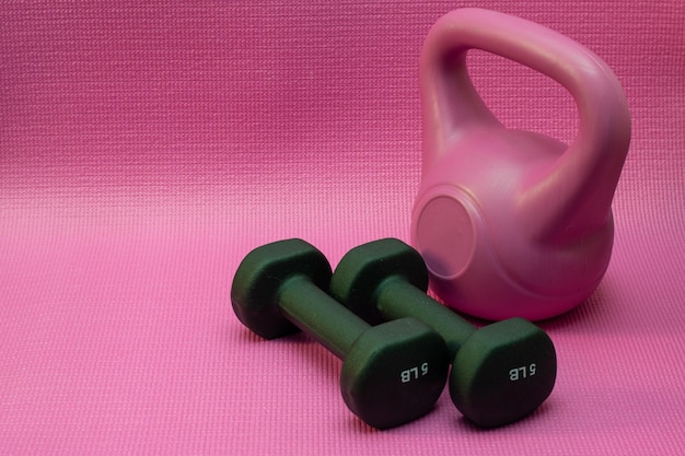 A pink dumbbell and a pink dumbbell on a pink background.