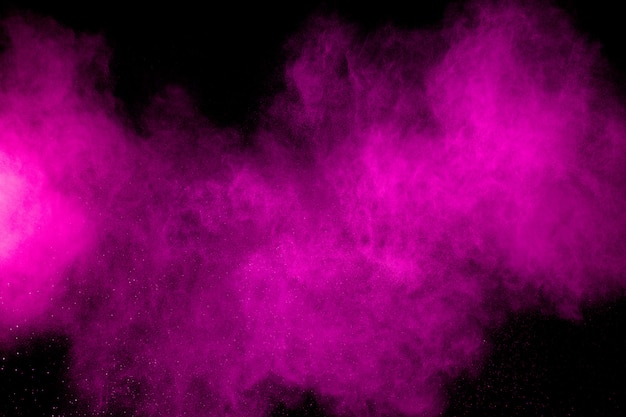 Pink dust particles splash on black surface