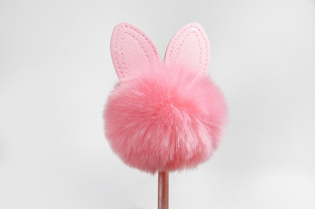 Pink Easter Bunny from fur silhouette on a pink stick isolated on a white background Souvenir decoration for Easter Easter concept copy space