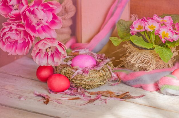 Pink Easter eggs in fresh flowers tulip Easter background with copy space